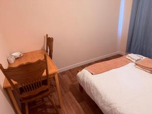 a bedroom with a bed and a wooden table and chair at Kirkar Flat in Penton Mewsey