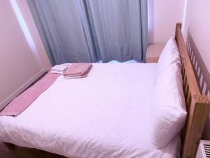a bed with white sheets and a towel on it at Kirkar Flat in Penton Mewsey