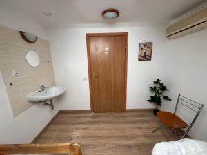 a bathroom with a sink and a wooden door at Motel S7 in Goszczyn