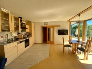 a kitchen with a table and a dining room at Apartment with Terrace & Garden View in Zwiesel