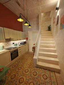a kitchen with a staircase in a kitchen at Ta' Dolor - Kalkara Heritage Maisonette in Kalkara