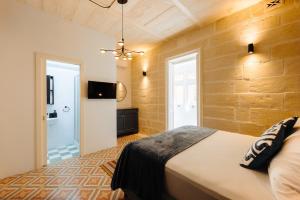 a bedroom with a bed and a television in a room at Ta' Dolor - Kalkara Heritage Maisonette in Kalkara
