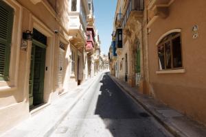 an empty street in an alley between two buildings at Ta' Dolor - Kalkara Heritage Maisonette in Kalkara
