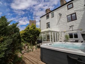 a hot tub in the backyard of a house at Tenandeleven Cottage in Denbigh