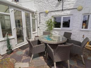 a patio with a table and chairs in front of a building at Tenandeleven Cottage in Denbigh