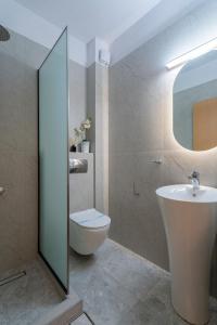 a bathroom with a toilet and a sink and a mirror at Kaplanis House in Neos Marmaras