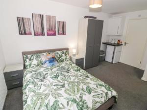 a bedroom with a bed with a green and white blanket at Lodge Park in Corby