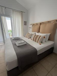 a large bed in a room with a large window at Angelos Studios in Ilia