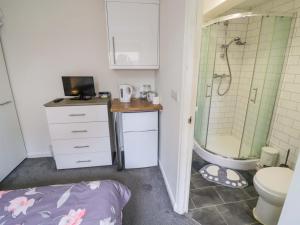 a bathroom with a shower and a toilet and a sink at Lodge Park in Corby
