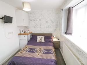 a small bedroom with a bed and a window at Lodge Park in Corby