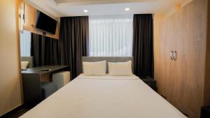 a bedroom with a large white bed and a television at Blue Serenity Hotel in Side