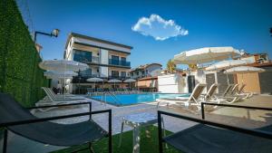 a swimming pool with chairs and umbrellas next to a building at Blue Serenity Hotel in Side