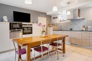 a kitchen with a wooden table and purple chairs at Chambres D'hôtes - Les Vergers in Muneville-sur-Mer