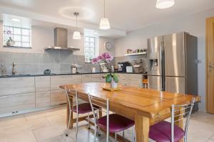 a kitchen with a wooden table and a refrigerator at Chambres D'hôtes - Les Vergers in Muneville-sur-Mer +24 photos