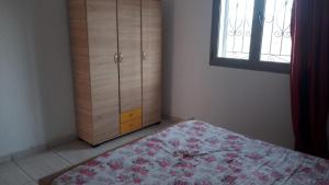 a bedroom with a bed and a dresser and a window at appart CRISTIANA 3 Midoun in Midoun