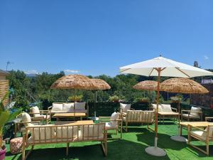 a group of chairs and tables with umbrellas at Hostal "Los Chanos el Ruso" in Galende