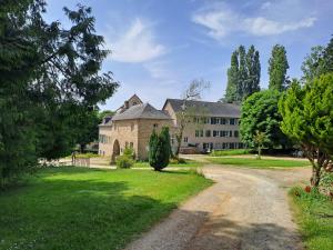 an old house with a dirt road in front of it at Hôtellerie Abbaye Port du Salut in Entrammes