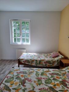 a bedroom with two beds and a window at Hôtellerie Abbaye Port du Salut in Entrammes