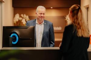 a man standing behind a podium with a woman at Parkhotel Papenburg by Hackmann in Papenburg