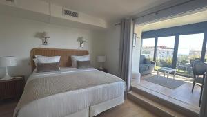 a bedroom with a large bed and a balcony at Hôtel de Provence in Cannes