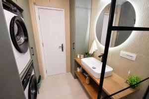 a bathroom with a sink and a washing machine at Apartments Krivokapic in Perast