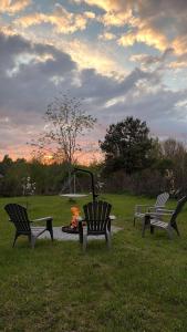 three benches in a park with a fire in the grass at Przystanek Dobra in Dobra