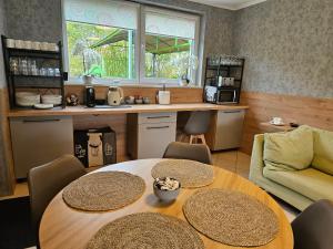 a kitchen with two wooden tables and a kitchen with a couch at Gościnne Zacisze in Grzybowo