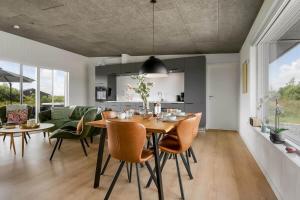 a dining room and living room with a table and chairs at C11319-Tarm-Multebaervej-33 in Tarm