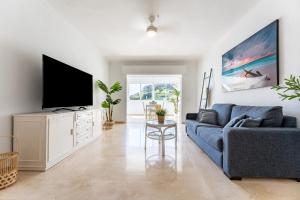 a living room with a blue couch and a tv at El Rey in Fuengirola