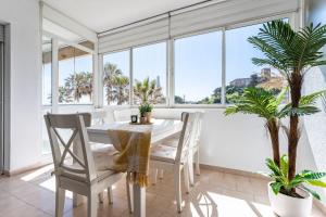 a dining room with a table and chairs and windows at El Rey in Fuengirola