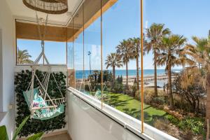 a room with a view of the beach and palm trees at El Rey in Fuengirola