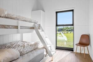 a bedroom with a bunk bed and a chair and a window at LF12002-Spottrup-Molleparken-17 in Spottrup