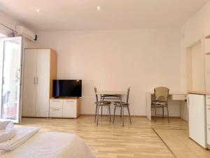 a bedroom with a table and two chairs and a tv at Apartments Pine in Primošten