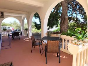 a patio with tables and chairs and a tree at Apartments Pine in Primošten