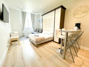 a bedroom with a bed and a table in a room at Hôtel de Provence in Cannes