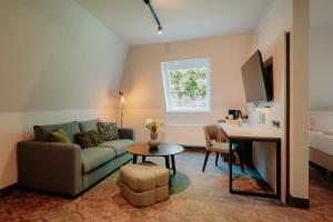 a living room with a couch and a table at Parkhotel Papenburg by Hackmann in Papenburg
