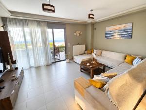 a living room with a couch and a table at Alkion Villa Sea View, Olive Tree Garden & Spacious Terrace in Rhodes Town