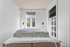 a bed in a white room with a window at 8566-Grenaa-Askevej-17 in Grenå