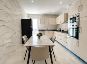 a kitchen with a table with chairs and a refrigerator at Appartement Spacieux à Constantine in El Khroub