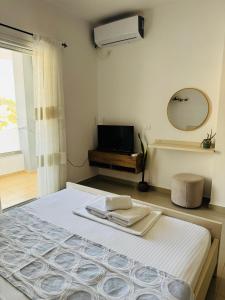 a bedroom with a bed with a mirror and a television at Vitamin Sea in Sarandë +56 photos