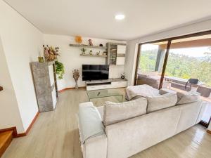 a living room with a white couch and a television at Abadia House - Geres in Geres
