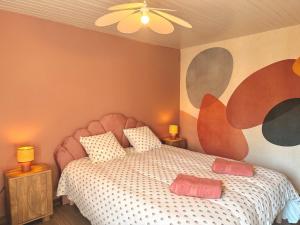 a bedroom with a bed and a painting on the wall at Les Terres Beaujolaises in Belleville-en-Beaujolais