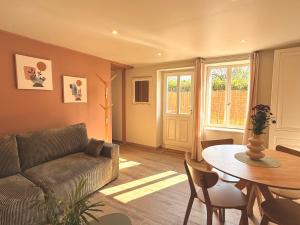 a living room with a couch and a table at Les Terres Beaujolaises in Belleville-en-Beaujolais