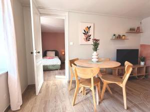 a dining room with a table and chairs and a bedroom at Les Terres Beaujolaises in Belleville-en-Beaujolais