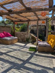 a pergola with two couches and chairs under it at All About You Montefiore in Casola in Lunigiana