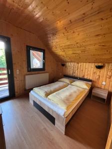 a bedroom with a bed in a wooden room at Bergblick in Arpaşu de Sus