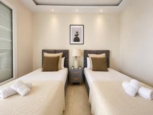 two beds in a room with white walls at Appartement Spacieux à Constantine in El Khroub