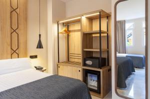 a bedroom with a bed and a tv and a mirror at Porcel Navas in Granada +52 photos