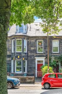 a house with two cars parked in front of it at GuestReady - Links View in Edinburgh