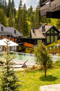a view of a resort with a pool and trees at Котеджі Грань in Yablunytsya